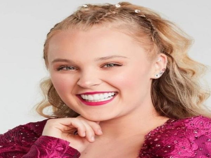 Chris Hughes gifts JoJo Siwa a bouquet of flowers at airport