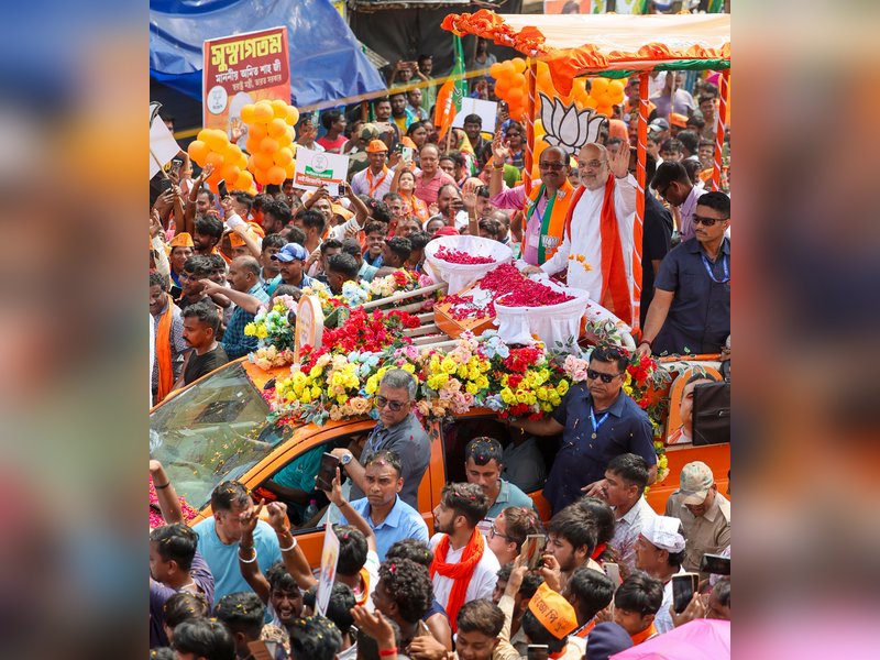 Hooghly: Union Home Minister Amit Shah waves to supporters during a roadshow in support of Bharatiya Janata Party candidate from Chandannagar Assembly constituency Dipanjan Guha ahead of the second phase of the West Bengal Assembly election in Chandannagar, Hooghly on Monday, April 27, 2026. (Photo: IANS/X/@AmitShah)