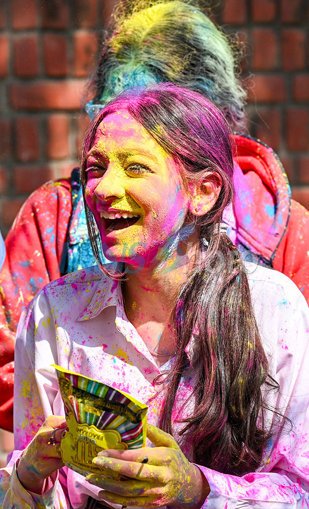 People celebrate pre-Holi with gulal.